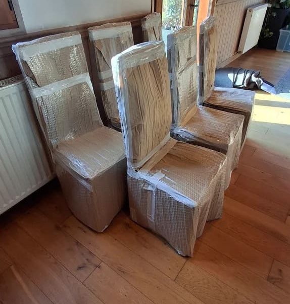 Chaises emballées dans du papier bulle dans une maison en cours de déménagement